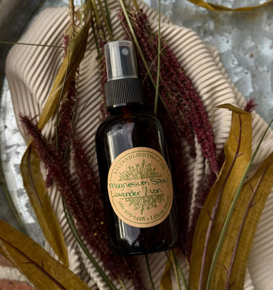 Bottle of magnesium spray with a label on a textured surface with dried plants. At The Salt and Light House