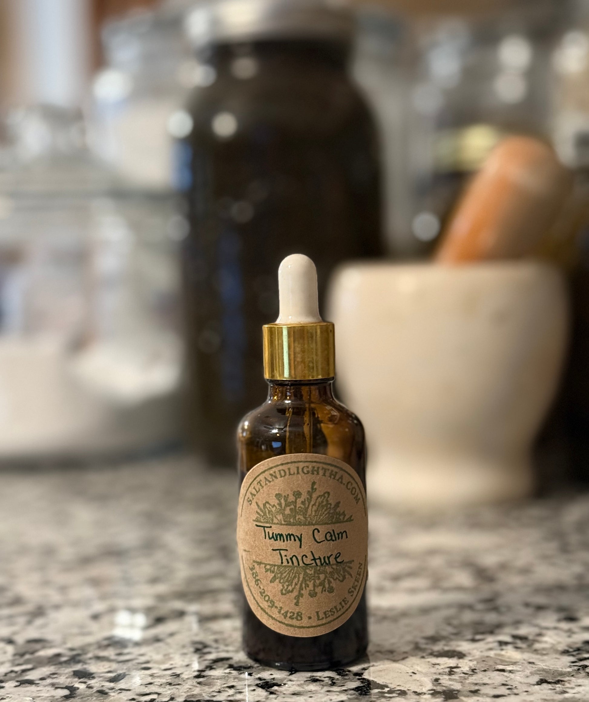Bottle of Tummy Calm Tincture with dropper on a countertop